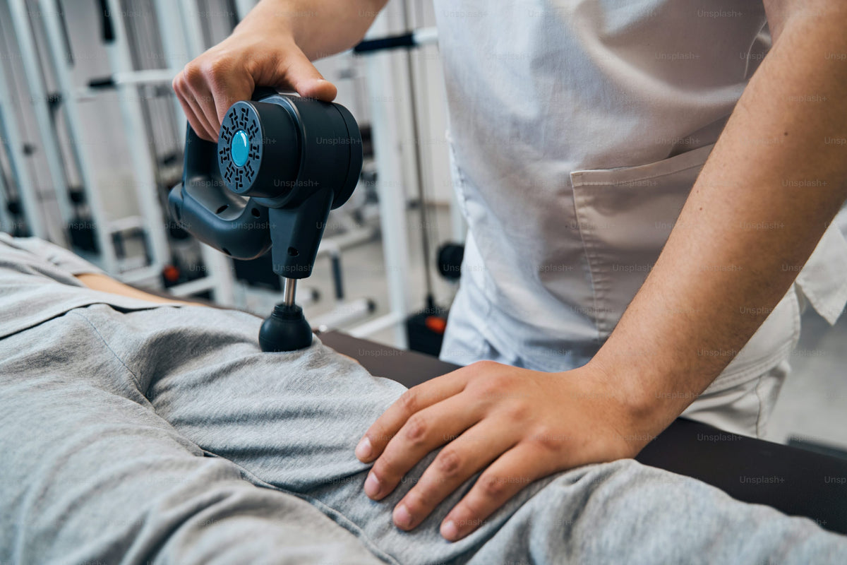 Percussion massage gun used for muscle recovery